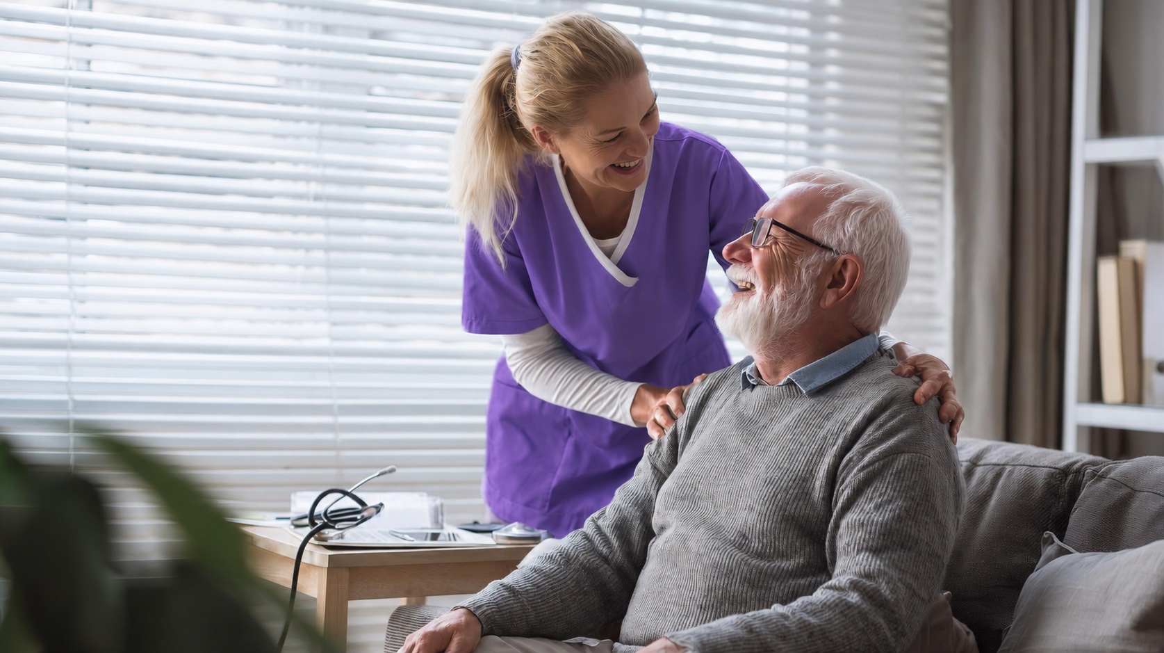 Nurse in purple scrubs connecting warmly with an older adult during a home visit